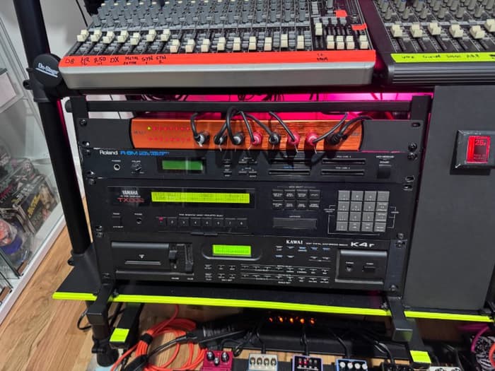 A rack of gear that includes a Yamaha TX-802, a Kawai K4r, and a Roland R8m.
